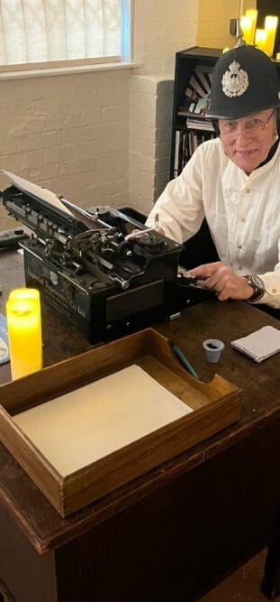 A pen Museum volunteer dressed for a murder mystery